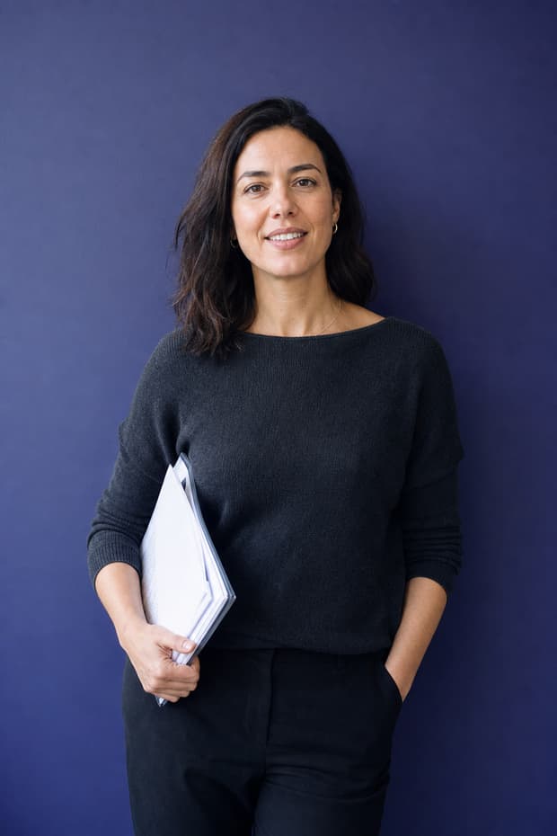 A woman holding a folder of printed pages