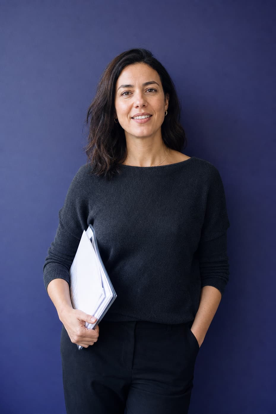 A woman holding a folder of printed pages