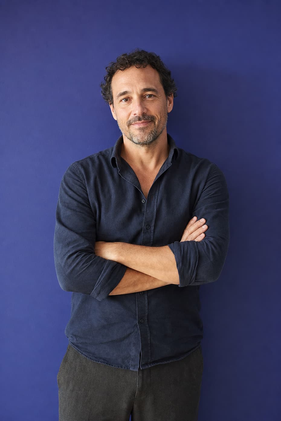 An experienced colleague with arms folded